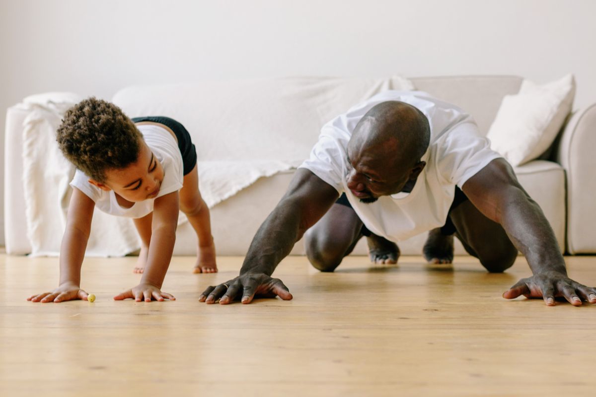 Enfant réalisant des exercices avec un adulte dans un salon