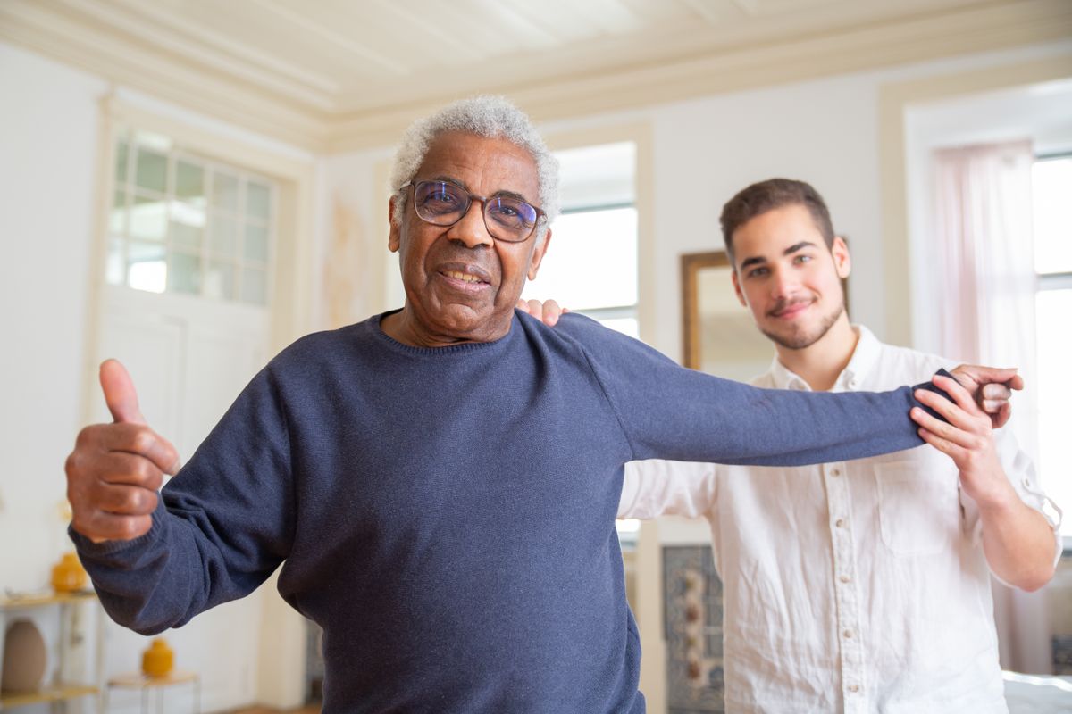 Personne âgée souriante accompagnée lors d’exercices à domicile
